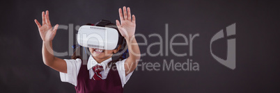 Schoolgirl using virtual reality headset against blackboard