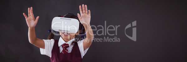 Schoolgirl using virtual reality headset against blackboard