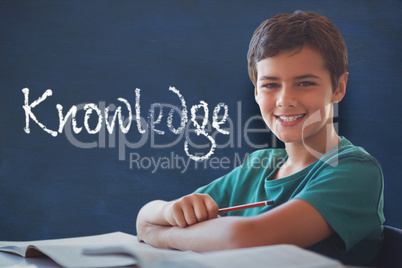Composite image of portrait of boy doing homework