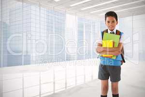 Composite image of portrait of schoolboy holding books over white background