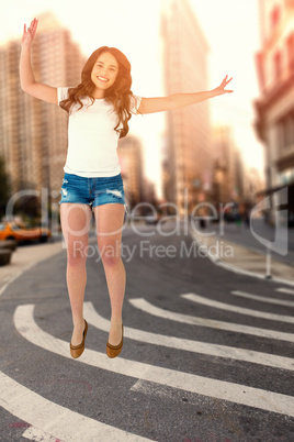 Composite image of pretty brunette jumping