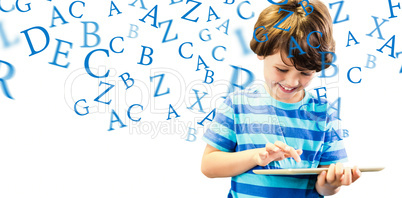 Composite image of smiling boy using digital tablet