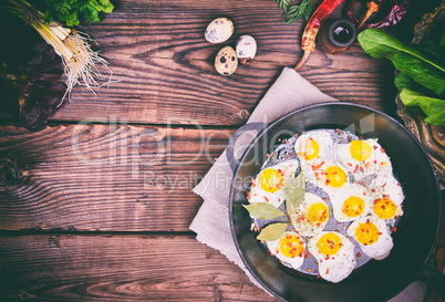Fried quail eggs in a cast-iron frying pan