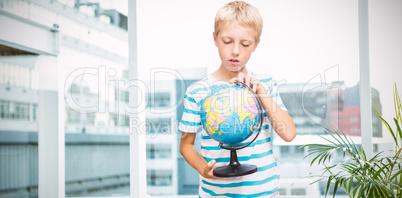 Composite image of boy looking at globe