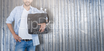 Composite image of portrait of man wearing hat carrying water bottles in bag