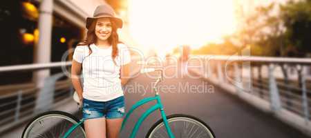 Composite image of portrait of smiling woman with bicycle