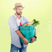 Composite image of man carrying vegetables in shopping bag against white background