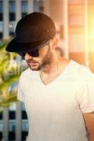 Composite image of model wearing black cap and sunglasses