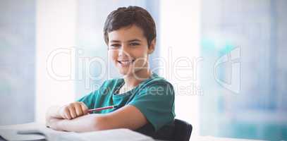 Composite image of portrait of boy doing homework