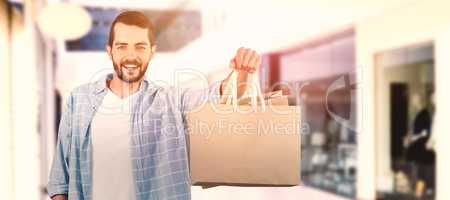 Composite image of happy man holding shopping bag