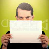 Composite image of portrait of young man hiding face with cardboard