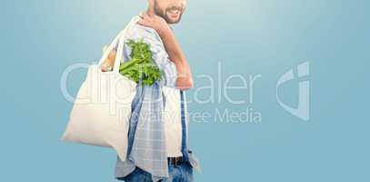 Composite image of portrait of man carrying vegetables in shopping bag