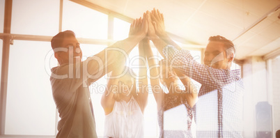 Portrait of business people raising hands seen through glass