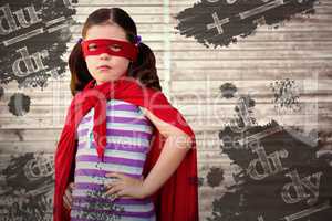 Composite image of portrait of girl standing in superhero costume