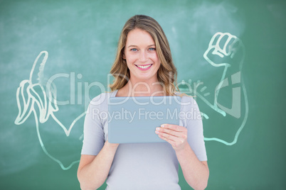 Composite image of smiling teacher using digital tablet in front of blackboard