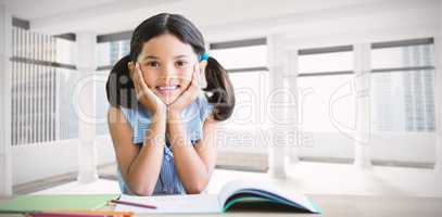 Composite image of portrait of girl doing homework at desk