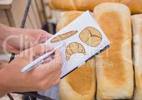Drawing bread on notepad with bread in background