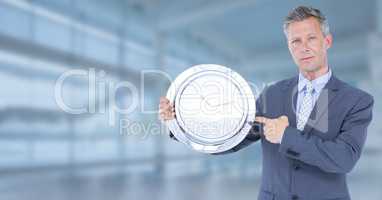 man holding clock in front of glass hall