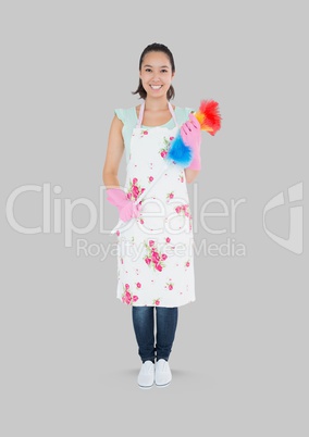 Full body portrait of cleaner woman holding duster standing with grey background