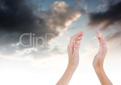 Hands cupped together in front of sky