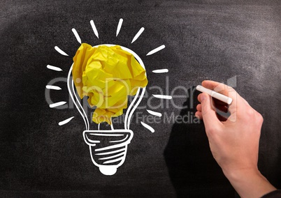 Hand drawing light bulbs on blackboard with chalk and crumpled paper balls on blackboard