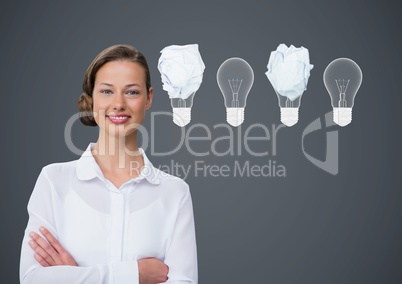 Woman standing next to light bulbs with crumpled paper balls in front of blackboard