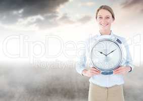 Woman holding clock in front of clouds