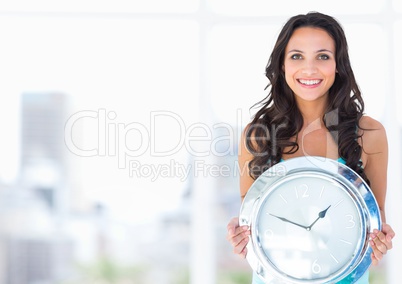 Woman holding clock in front of bright blur