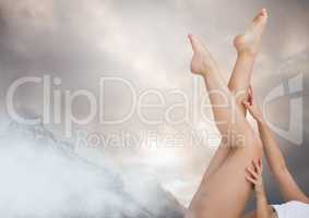 Woman's legs sticking up in the air with clouds