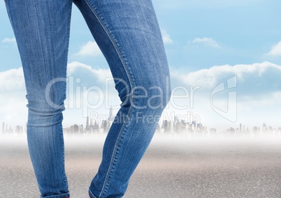 Woman's legs in front of city landscape in jeans