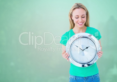 Woman holding clock in front of green background