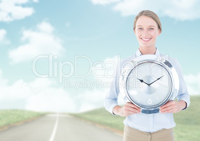 Woman holding clock in front of road