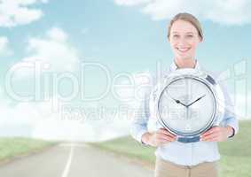 Woman holding clock in front of road