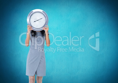 Woman holding clock in front of blue background