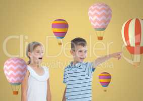 kids pointing surprised with blank room background with hot air balloons