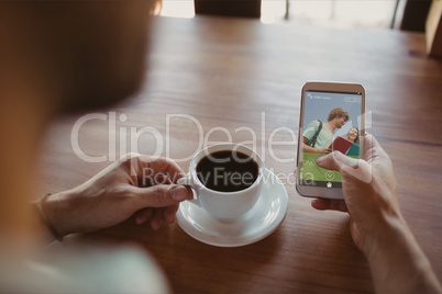 Man holding a phone with E-Learning information in the screen