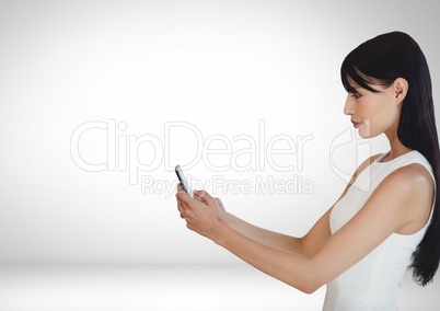 Woman on phone standing in white room
