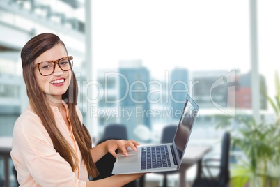 Happy business woman using computer against office background