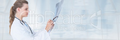 Doctor woman looking at a radiography against blue background