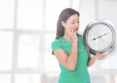 Woman holding clock in front of windows