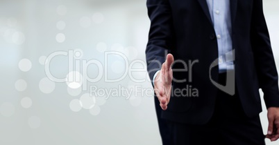 Business man giving hand against white blurred background