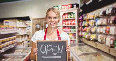 Small business owner holding a small blackboard with the word open