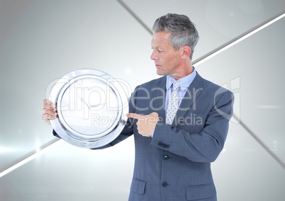 Woman holding clock in front of shiny chrome silver grey background