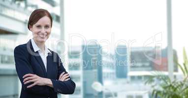 Happy business woman standing against office background