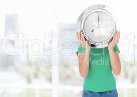 Woman holding clock in front of bright background