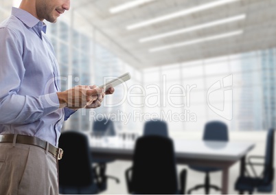 Business man holding a tablet against office background