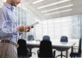 Business man holding a tablet against office background