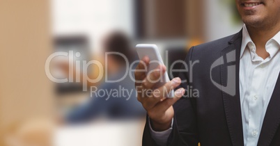 Business man looking at a phone against office background