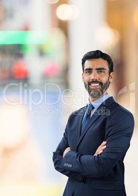 Happy business man standing against background with lights