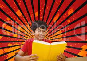 Happy boy reading against red, black and orange splattered background